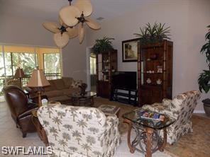 3985 Deer Crossing Court, Unit 201 Naples, FL 34114 - Photo 4 of 24 a living room with furniture chandelier and a fireplace