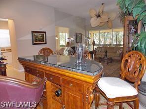 3985 Deer Crossing Court, Unit 201 Naples, FL 34114 - Photo 7 of 24 a dining room with furniture a large window and a chandelier