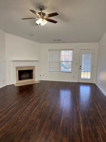 a view of wooden floor fire place refrigerator and window in a room