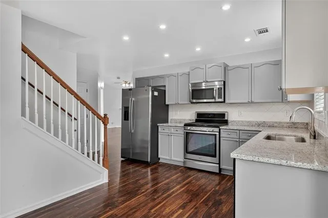a kitchen with granite countertop stainless steel appliances and wooden cabinets