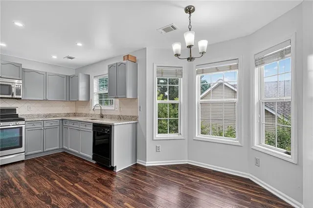 a kitchen with stainless steel appliances granite countertop a stove and a white cabinets