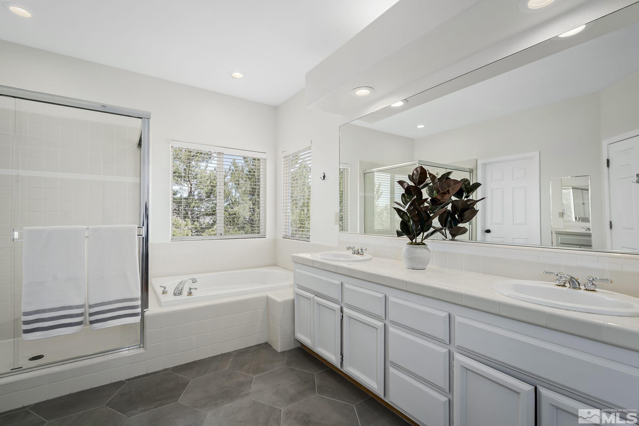 5016 East Albuquerque Road Reno, NV 89511 - Photo 22 of 38 a bathroom with a bathtub sink and mirror
