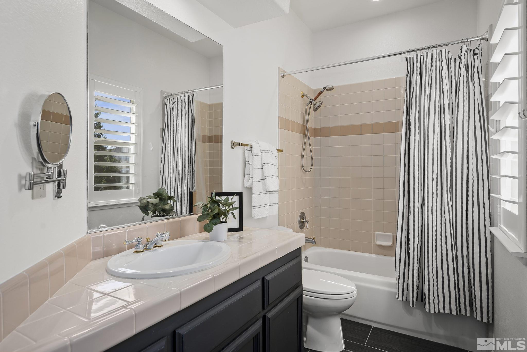 5016 East Albuquerque Road Reno, NV 89511 - Photo 26 of 38 a bathroom with a granite countertop sink toilet and shower