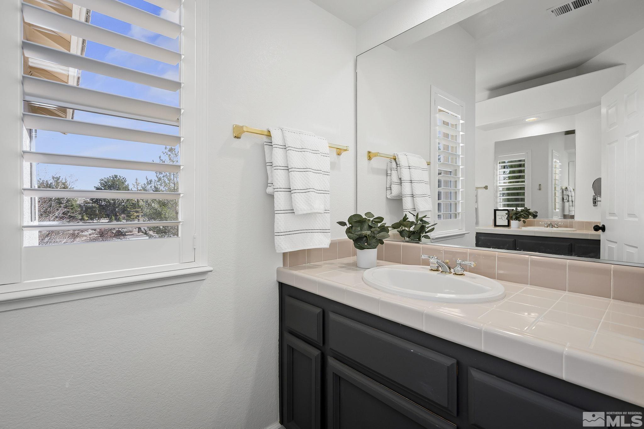 5016 East Albuquerque Road Reno, NV 89511 - Photo 27 of 38 a bathroom with a sink and a mirror