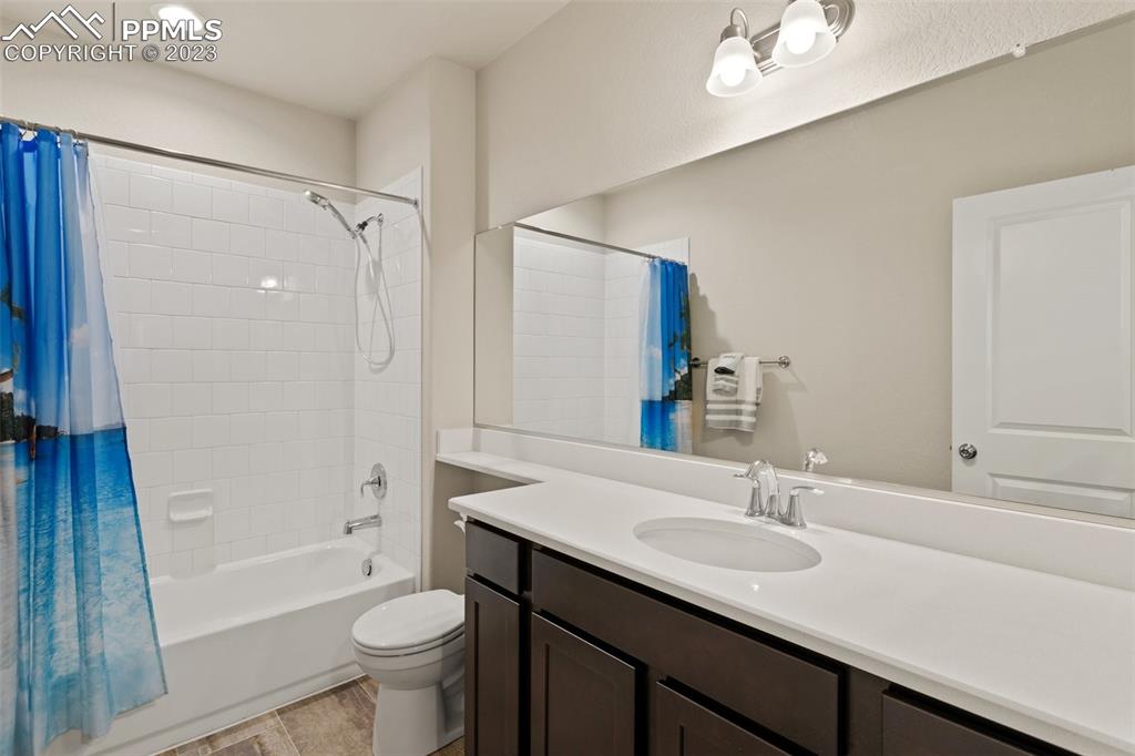 10095 Keating Drive Peyton, CO 80831 - Photo 19 of 31 a bathroom with a sink a toilet a mirror a bathtub and shower