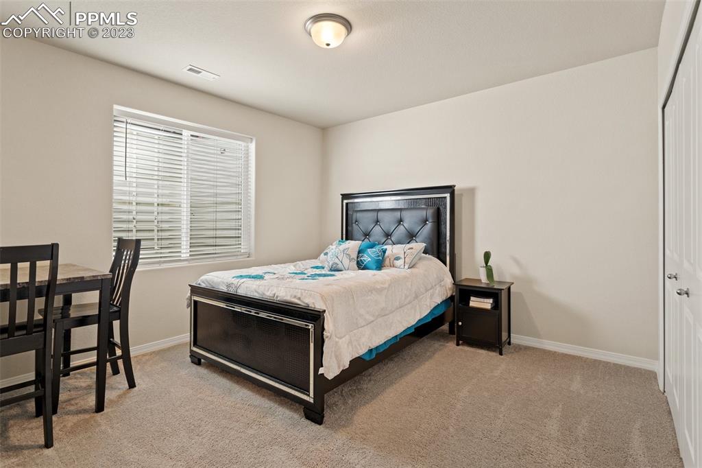 10095 Keating Drive Peyton, CO 80831 - Photo 20 of 31 a bed sitting in a spacious bedroom next to a window