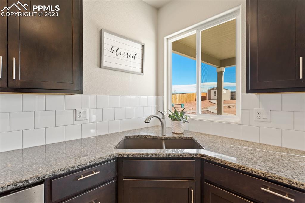 10095 Keating Drive Peyton, CO 80831 - Photo 6 of 31 a kitchen with granite countertop a sink and a stove