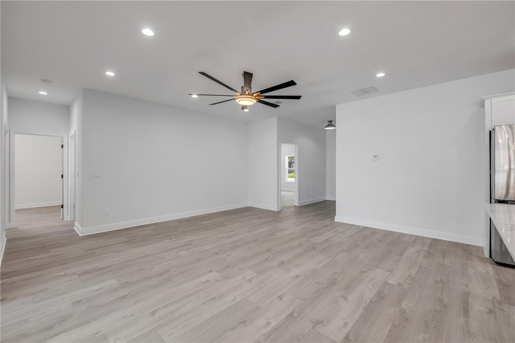 2324 Orange Tree Drive Edgewater, FL 32141 - Photo 12 of 59 an empty room with wooden floor and a ceiling fan