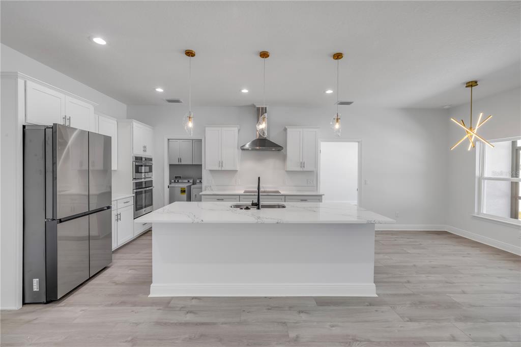 2324 Orange Tree Drive Edgewater, FL 32141 - Photo 15 of 59 a large kitchen with stainless steel appliances kitchen island a large counter top and a refrigerator