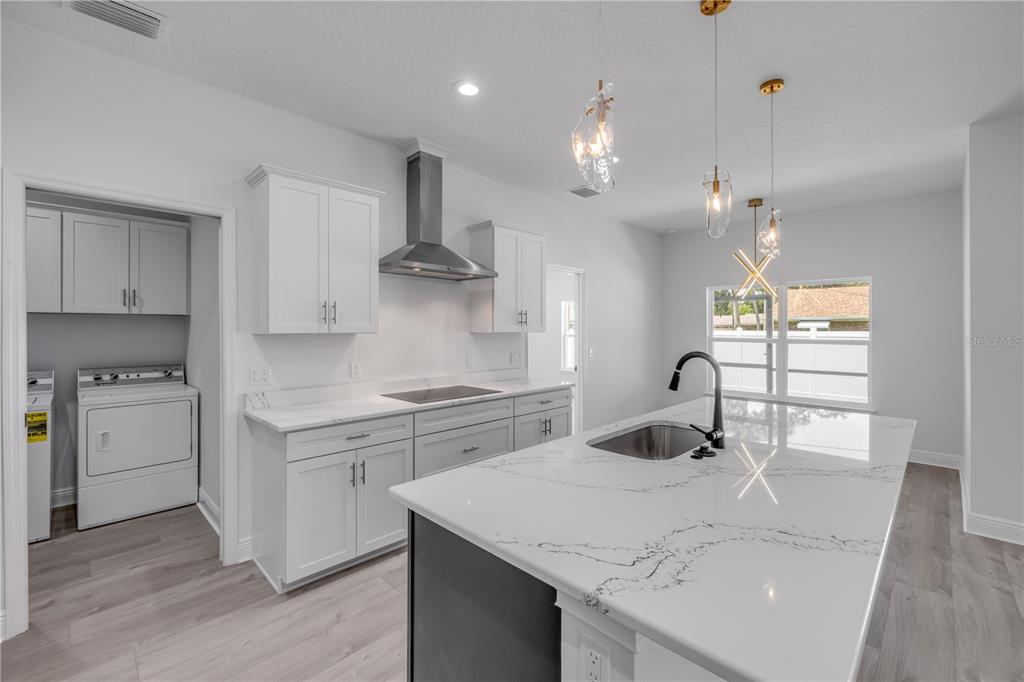 2324 Orange Tree Drive Edgewater, FL 32141 - Photo 18 of 59 a kitchen with a sink a stove and chairs