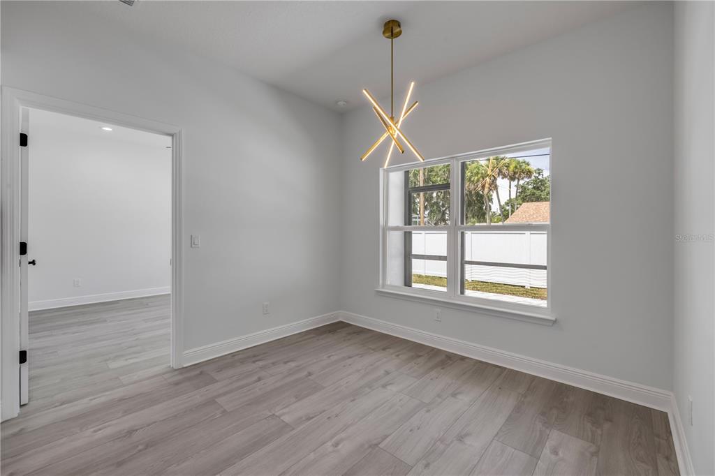 2324 Orange Tree Drive Edgewater, FL 32141 - Photo 26 of 59 a view of an empty room with wooden floor and a window