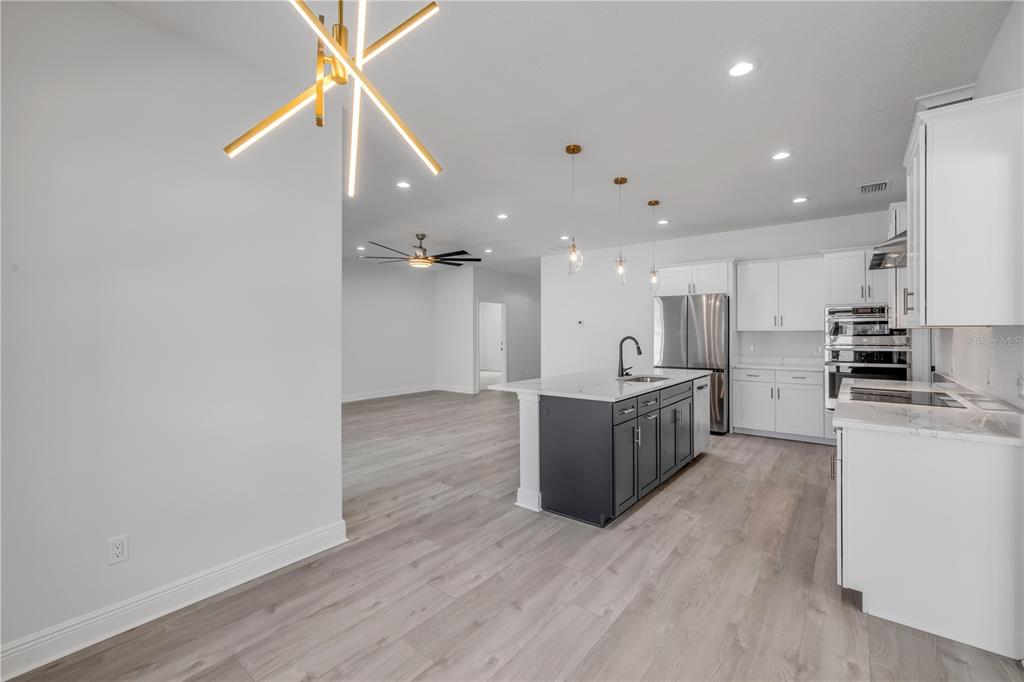 2324 Orange Tree Drive Edgewater, FL 32141 - Photo 27 of 59 a large kitchen with kitchen island a sink wooden floor and stainless steel appliances