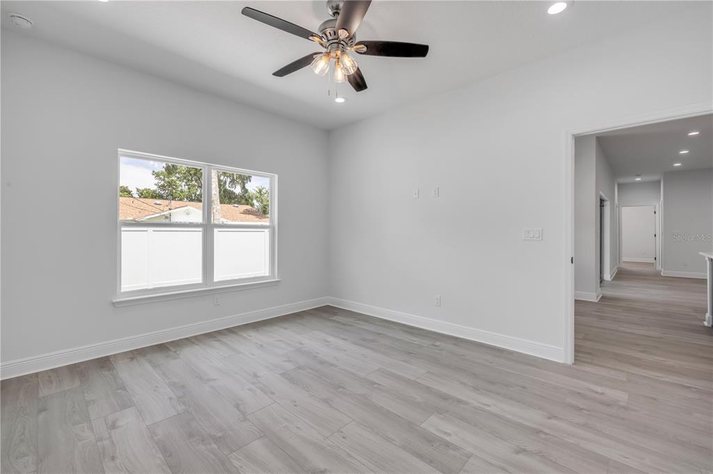 2324 Orange Tree Drive Edgewater, FL 32141 - Photo 30 of 59 an empty room with wooden floor chandelier fan and windows