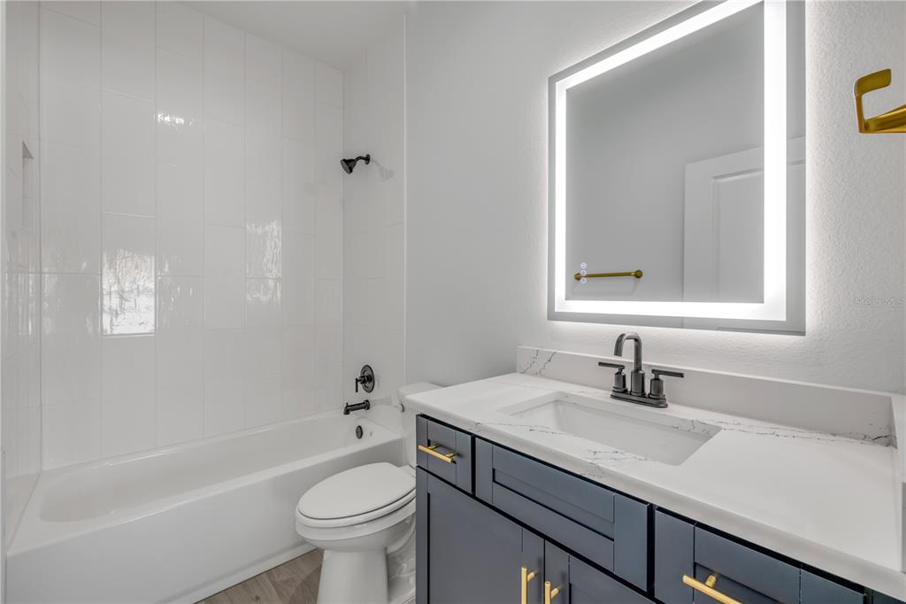 2324 Orange Tree Drive Edgewater, FL 32141 - Photo 39 of 59 a bathroom with a sink a toilet and a mirror