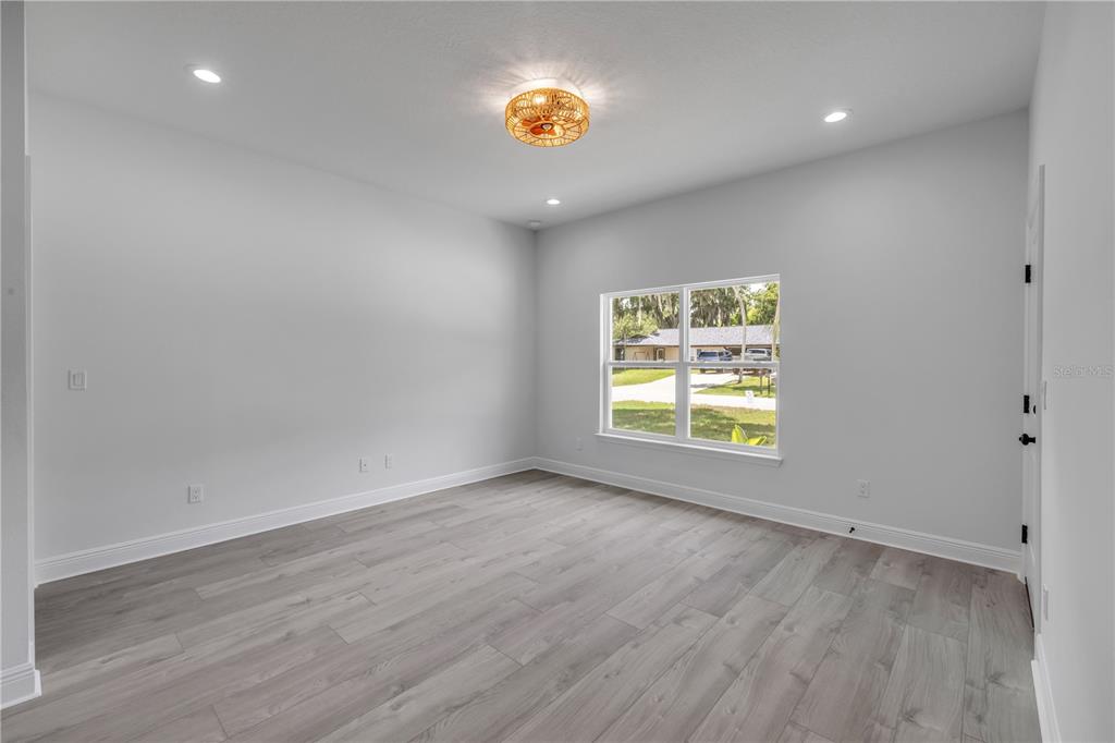 2324 Orange Tree Drive Edgewater, FL 32141 - Photo 41 of 59 an empty room with wooden floor and windows