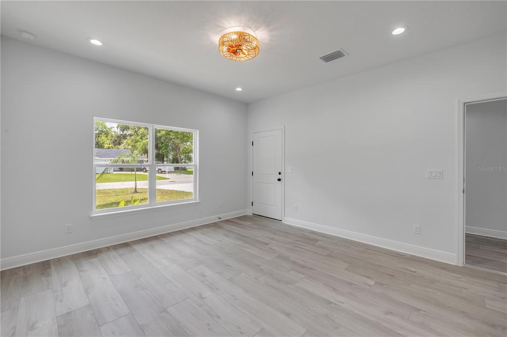 2324 Orange Tree Drive Edgewater, FL 32141 - Photo 44 of 59 an empty room with wooden floor and a window