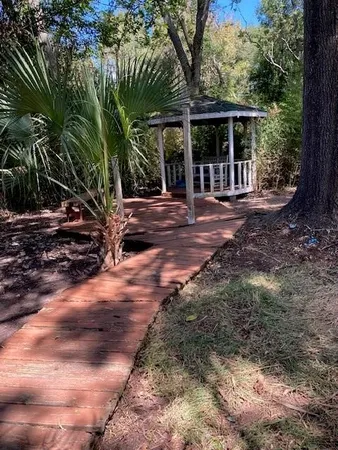 a view of a house with backyard and trees