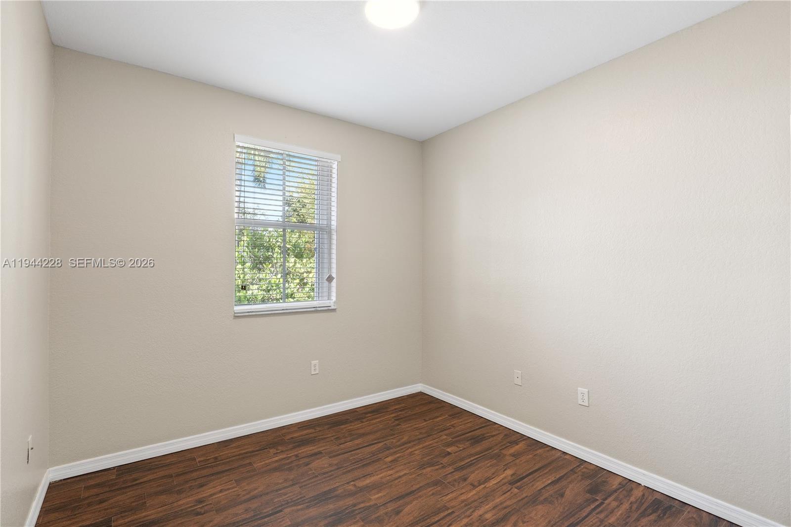 12476 Southwest 122nd Street Miami, FL 33186 - Photo 11 of 18 a view of an empty room with wooden floor and a window