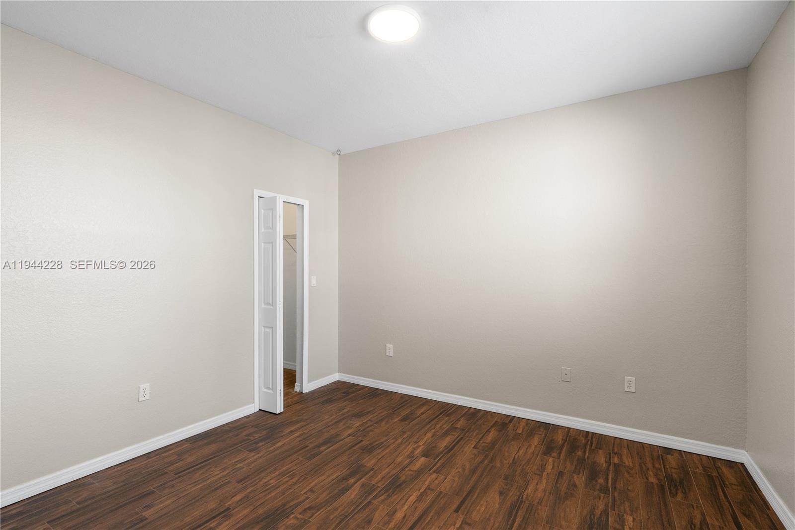12476 Southwest 122nd Street Miami, FL 33186 - Photo 13 of 18 a view of an empty room with wooden floor and a window