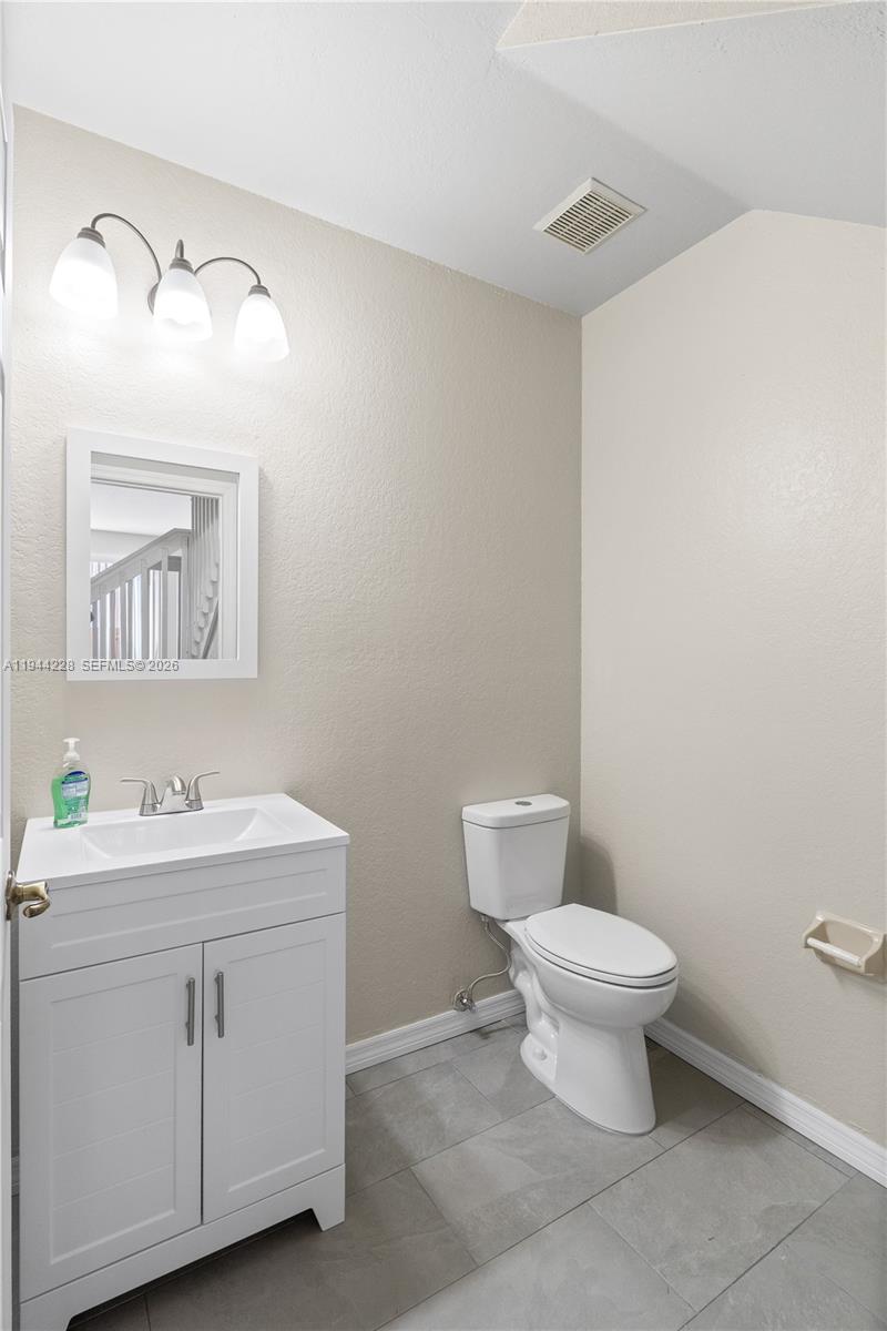 12476 Southwest 122nd Street Miami, FL 33186 - Photo 14 of 18 a bathroom with a toilet sink and mirror
