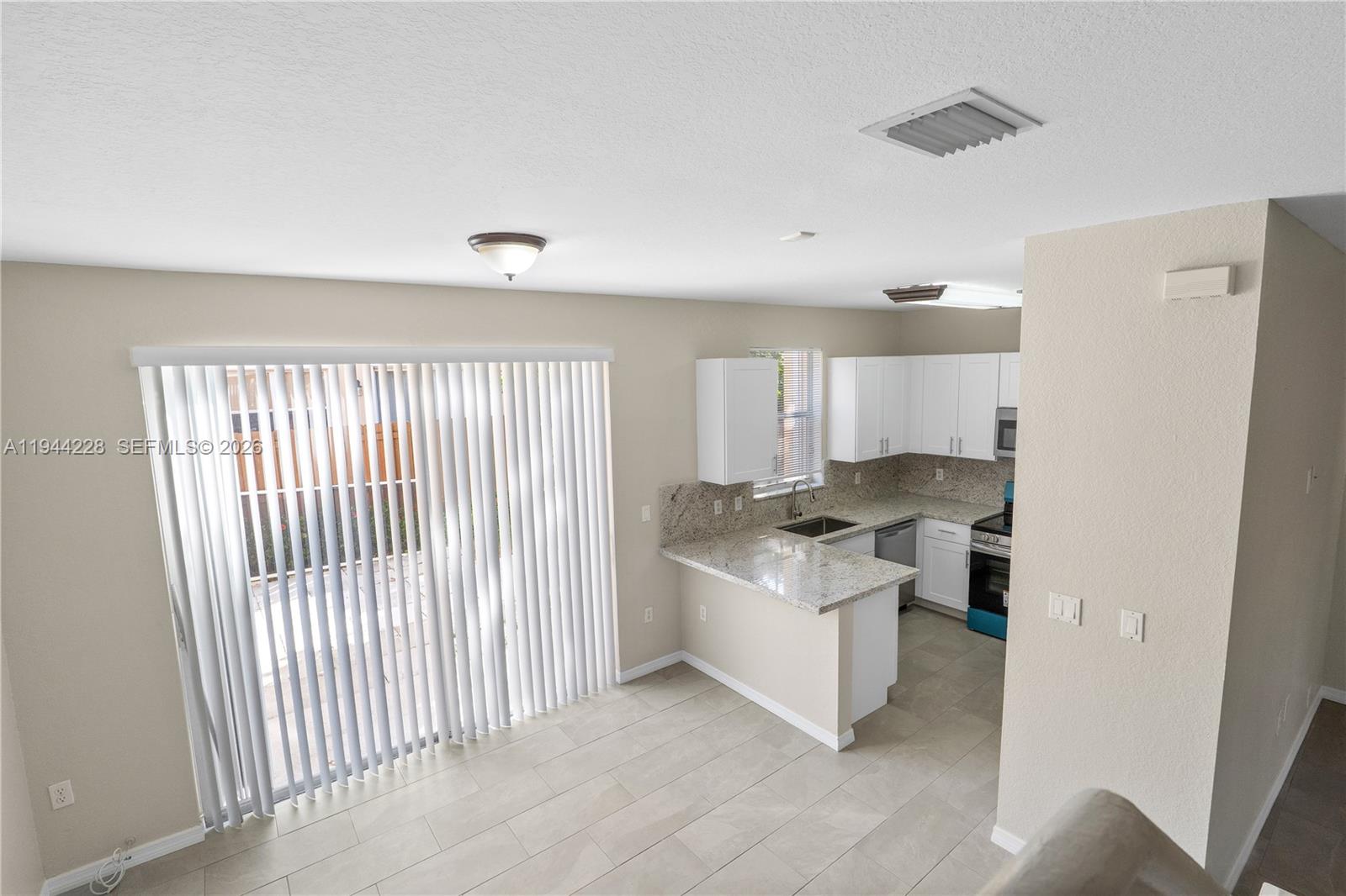 12476 Southwest 122nd Street Miami, FL 33186 - Photo 6 of 18 a living room with a couch and a stove top oven
