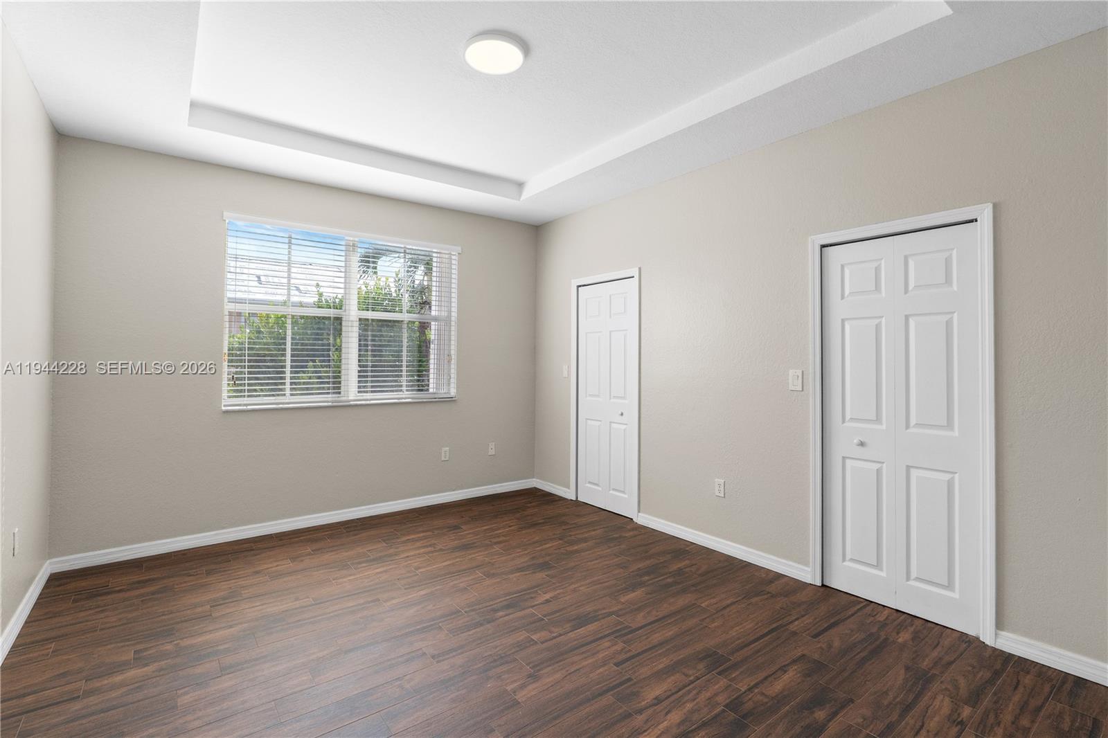 12476 Southwest 122nd Street Miami, FL 33186 - Photo 9 of 18 a view of an empty room with wooden floor and a window
