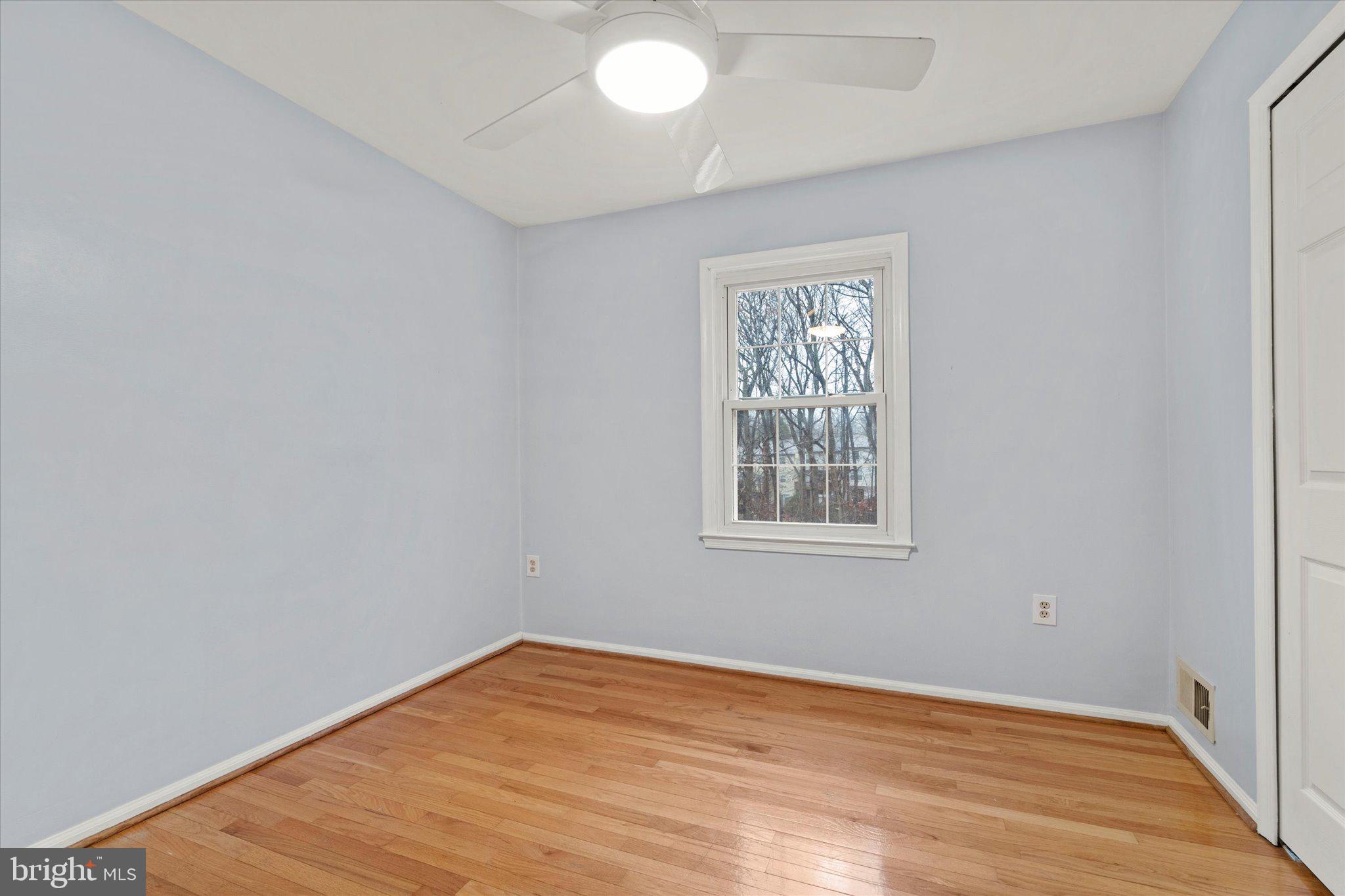 7907 Forest Path Way Springfield, VA 22153 - Photo 19 of 34 a view of an empty room with wooden floor and a window
