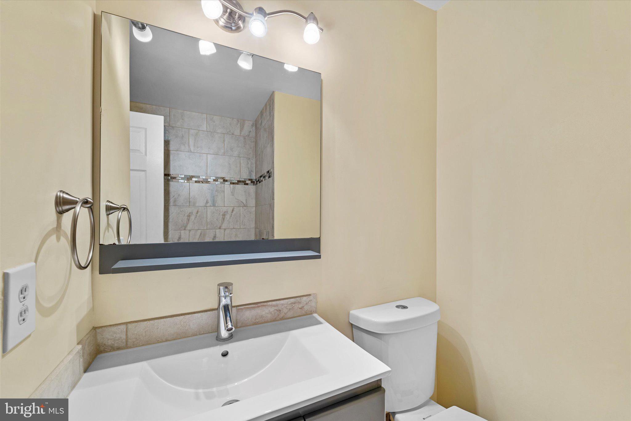 7907 Forest Path Way Springfield, VA 22153 - Photo 23 of 34 a bathroom with a sink a toilet and mirror