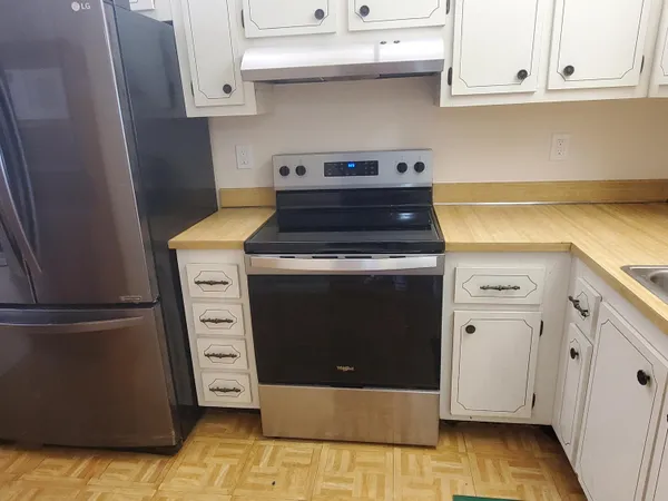 a kitchen with granite countertop white cabinets and white appliances