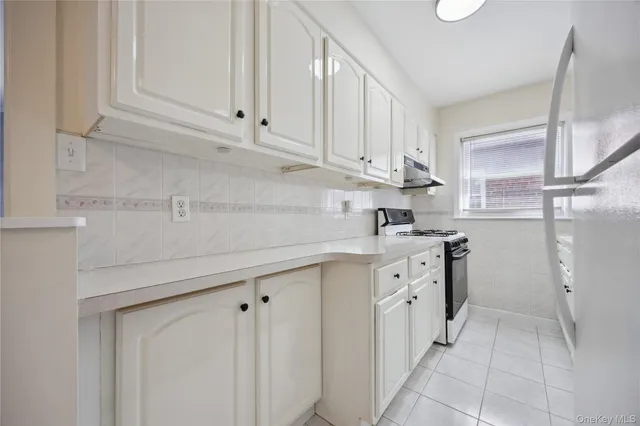 a kitchen with white cabinets and white appliances