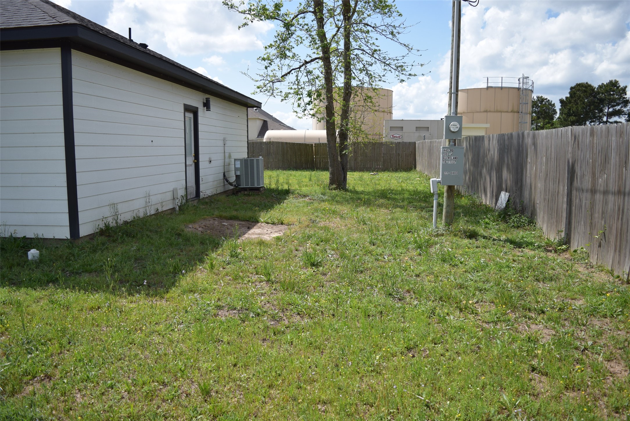 445 Road 5102 Cleveland, TX 77327 - Photo 35 of 36 a backyard of a house with plants and large tree