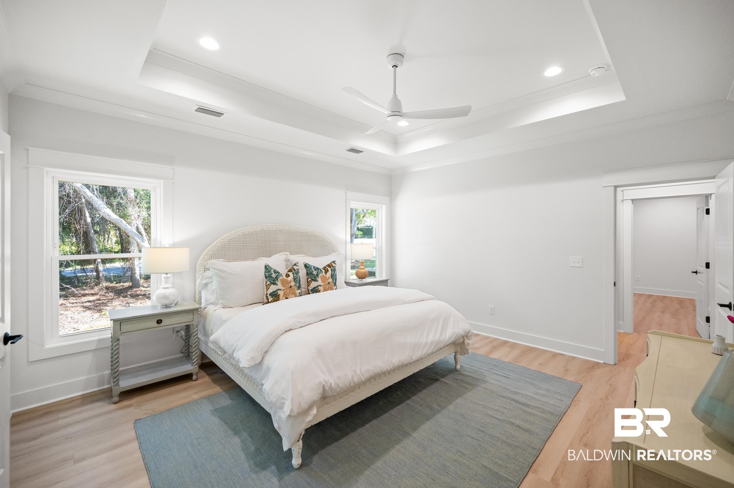28889 Canal Road Orange Beach, AL 36561 - Photo 36 of 55 Bedroom featuring ceiling fan, light wood-type flooring, crown molding, and a tray ceiling