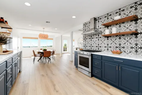 a kitchen with stainless steel appliances wooden floors wooden table and chairs