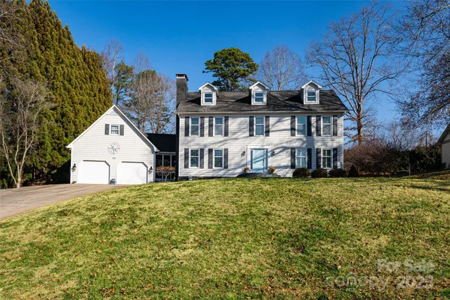 a view of a big house with a big yard and large tree