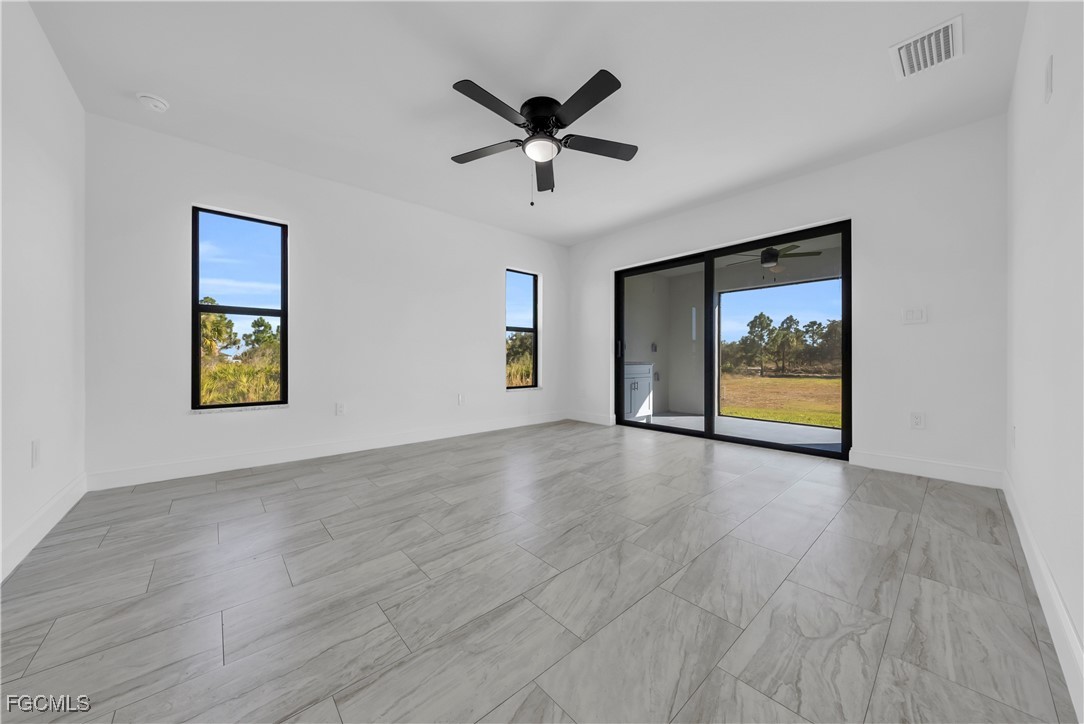 7979 16th Place LaBelle, FL 33935 - Photo 12 of 36 an empty room with wooden floor ceiling fan and windows
