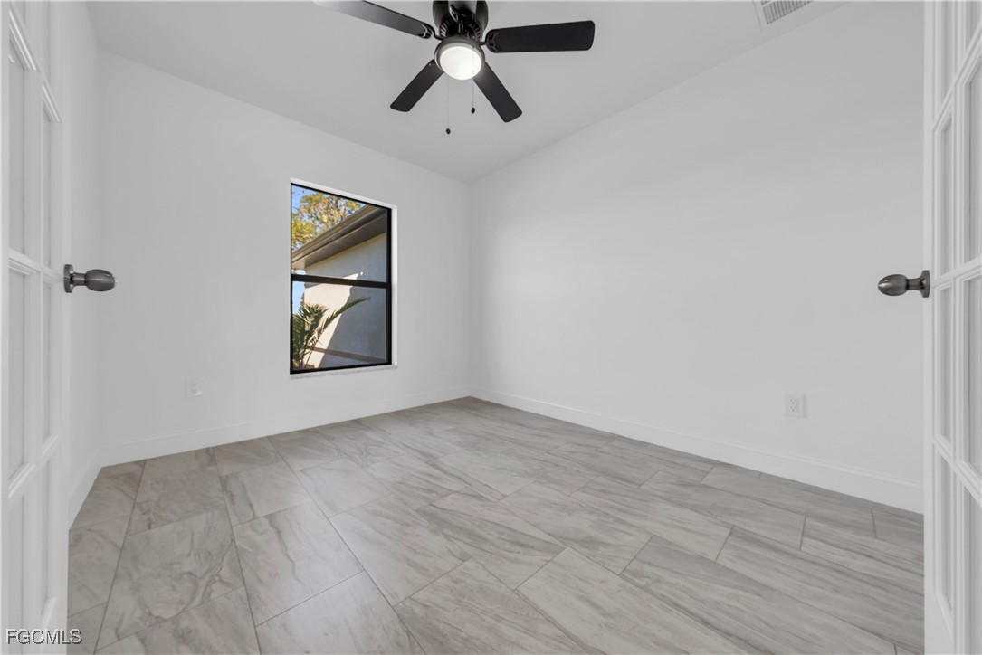 7979 16th Place LaBelle, FL 33935 - Photo 14 of 36 an empty room with windows and fan