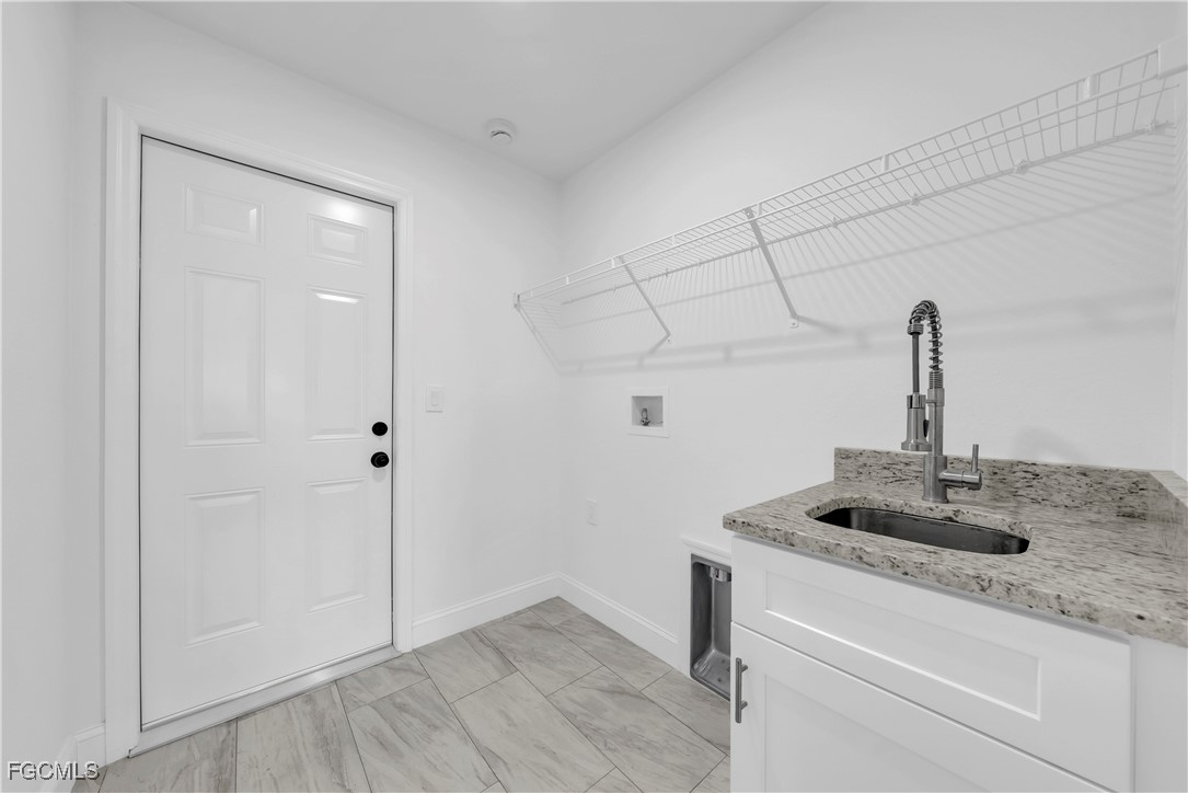 7979 16th Place LaBelle, FL 33935 - Photo 22 of 36 a bathroom with a granite countertop sink and white cabinets