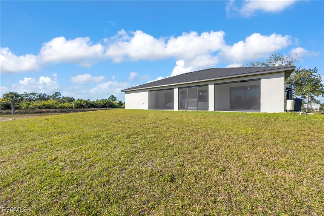 7979 16th Place LaBelle, FL 33935 - Photo 27 of 36 a view of a house with a yard and a large tree