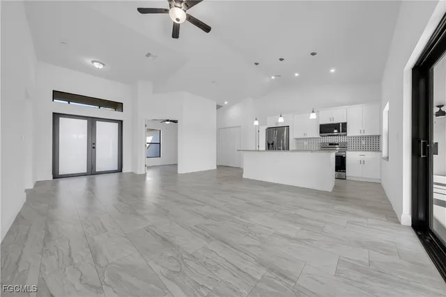 a kitchen with stainless steel appliances granite countertop a refrigerator a stove and a sink