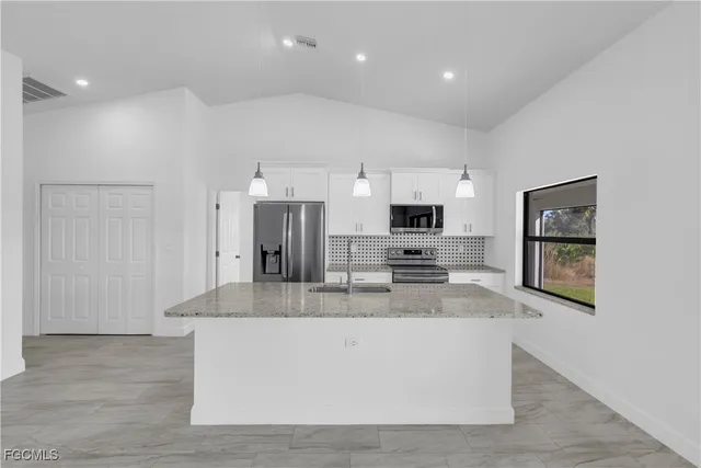 an empty room with wooden floor ceiling fan and windows