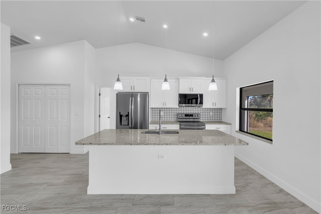 7979 16th Place LaBelle, FL 33935 - Photo 6 of 36 a large kitchen with stainless steel appliances a large counter top and a refrigerator