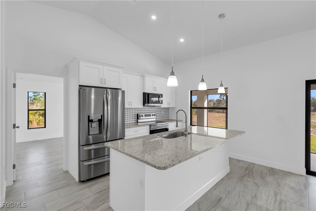 7979 16th Place LaBelle, FL 33935 - Photo 7 of 36 a kitchen with stainless steel appliances granite countertop a refrigerator a stove and a sink