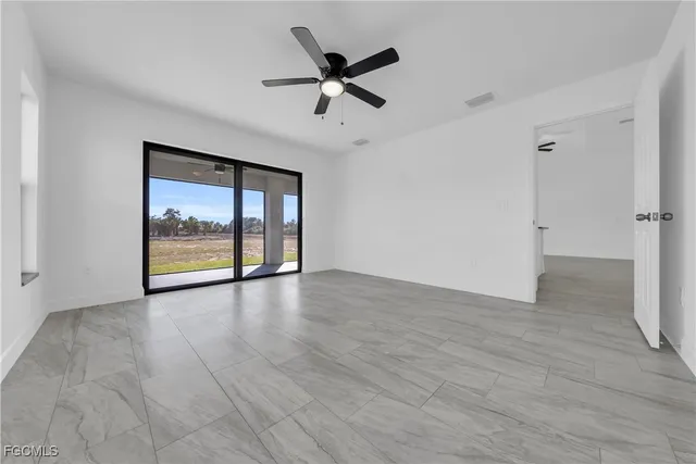 an empty room with closet and ceiling fan