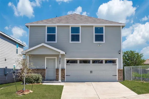 a front view of a house with a garden and plants