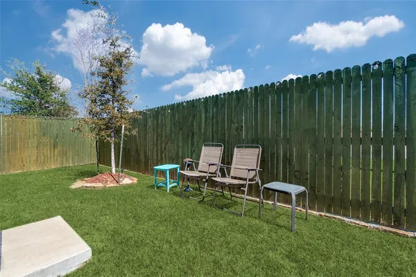 a backyard of a house with table and chairs