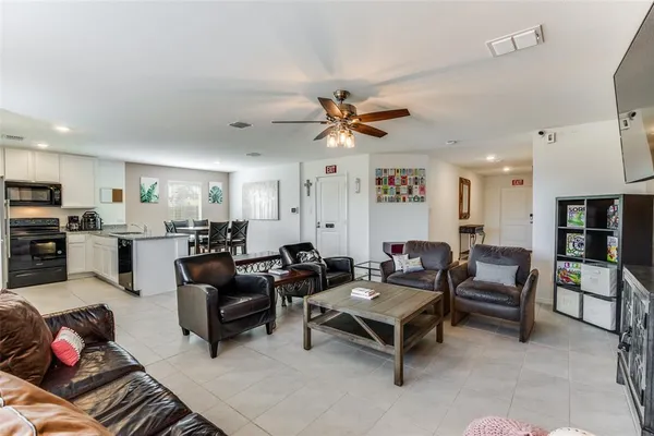 a living room with furniture kitchen view and a chandelier