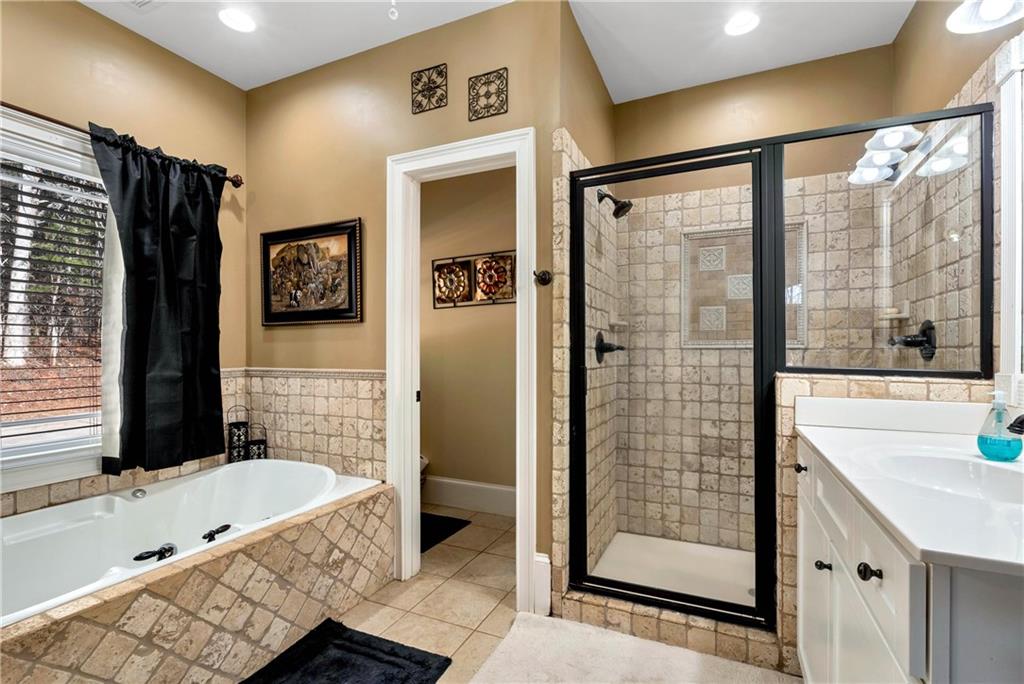 321 Chumbley Road Dawsonville, GA 30534 - Photo 25 of 65 a bathroom with a tub a sink and glass door shower