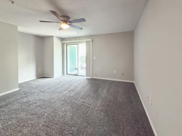 a view of a livingroom with a ceiling fan and window