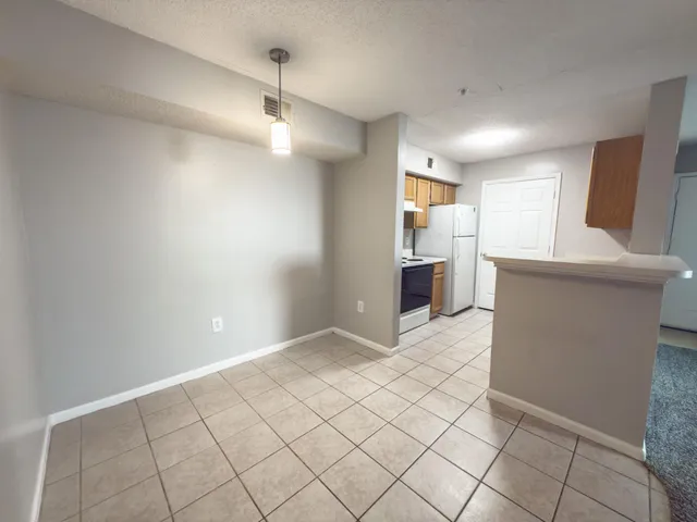 a view of a kitchen with a sink and dishwasher a refrigerator with white cabinets
