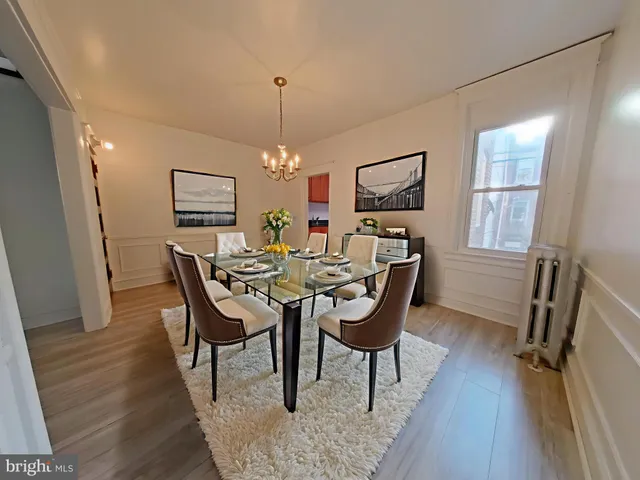 a dining room with furniture a chandelier and wooden floor